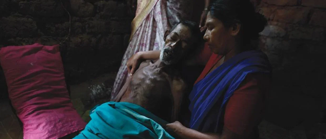 Sick man held by woman in India