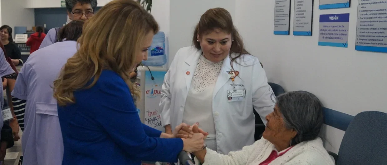 Felicia Marie Knaul holding hands with a female patient in Mexico