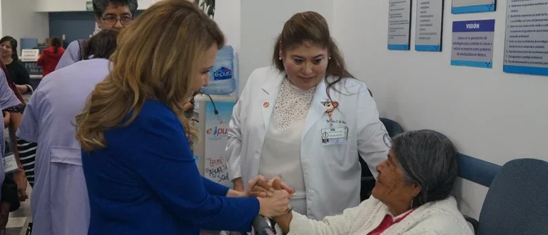 Felicia Marie Knaul holding hands with a female patient in Mexico